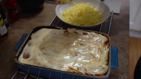 Dressing a Vegetarian Lasagne with grated cheese prior to oven cooking 