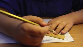 Close-up hands of a high school student draw a line along a ruler. A schoolboy at the workplace does his job. Education concept, modern school, knowledge acquisition, traditional learning. UHD 4K.