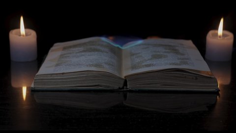An open book is on fire. Big bright flame, burning paper on old publication in slow motion in the dark. Book Burning - Censorship Concept