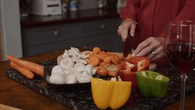 Caucasian elderly couple chopping vegetables in kitchen