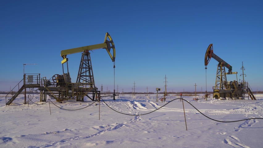 Oil pumps on a winter sunny and frosty day. Oil production in a snowy winter Royalty-Free Stock Footage #1086985826