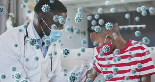 Animation of covid 19 cells over african american boy in face mask receiving vaccination. global covid 19 pandemic and healthcare concept digitally generated video.