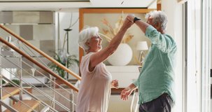 Animation of pink and purple confetti falling over happy caucasian senior couple dancing at home. retirement lifestyle, romance and celebration concept digitally generated video.