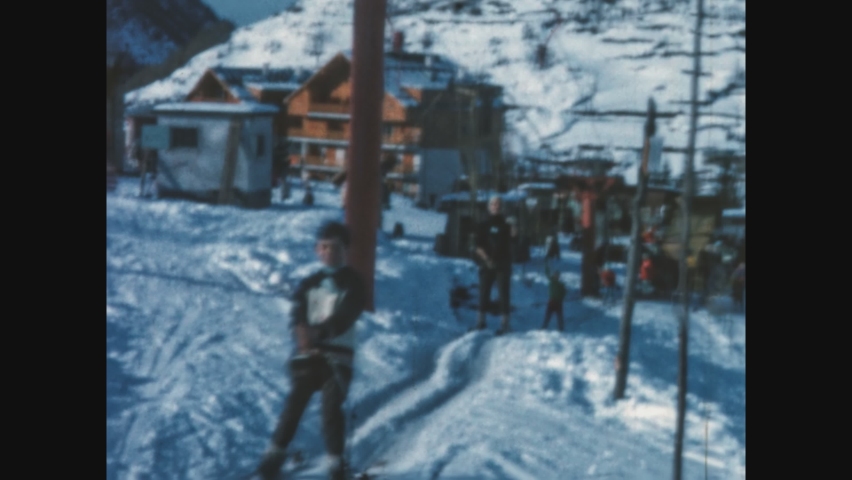 DOLOMITES, ITALY DECEMBER 1969: Smiling People go up the ski slope in 60's