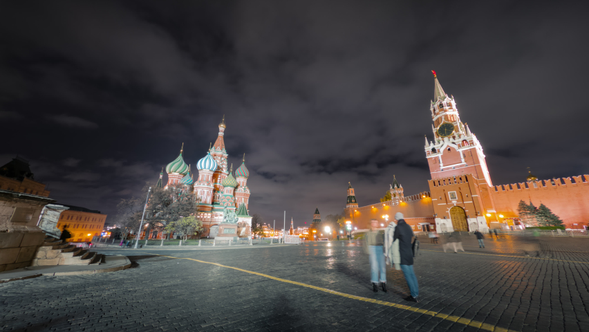 Beautiful panorama of Moscow Red Square at night with amazing views to the Cathedral of Vasily the Blessed and Spasskaya Tower of the Kremlin, and people moving around in motion timelapse.