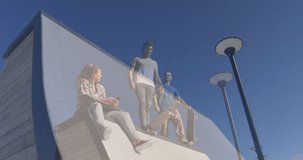 Composite video of tall building against group of friends skateboarding in the park. sports and hobby concept