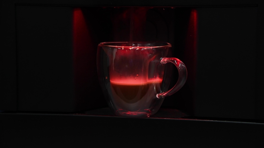 Real time video. Black automatic coffee machine pours Caffè Americano in double wall glass mug in office. The red light is on while coffee is being prepared. | Shutterstock HD Video #1087010633