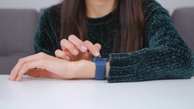 Woman using smart watches. Young female browsing notifications on wrist watches in closeup 4k video. Millenial person use modern mobile gadget for entertainment and communication online