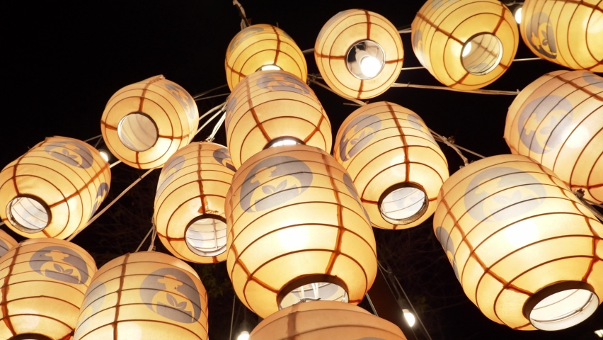 Lit up Japanese lanterns with light bulbs against dark night sky Royalty-Free Stock Footage #1087013333