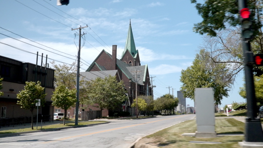 wide angle traveling image of the streets of Des moines in Iowa where we can see the small buildings passing in front of the camera during a summer day
