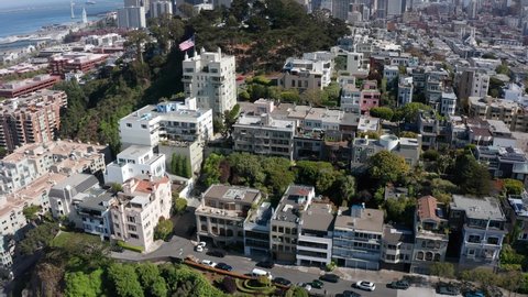 Aerial tilting up shot to reveal Coit Tower with the San Francisco skyline in the background on a clear day. 4K