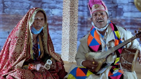 Pragati Maidan, New Delhi, India, 17th November 2021, Tribal man and woman performing live at the exhibition. Artist playing the Ektara and the Manjeera instrument together - entertainment, perform...
