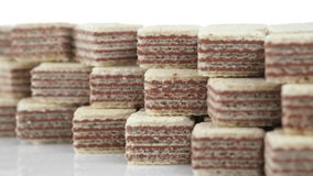 Square wafer biscuits isolated on white background. Sliding shot. Cocoa wafers close up. 4K UHD video.