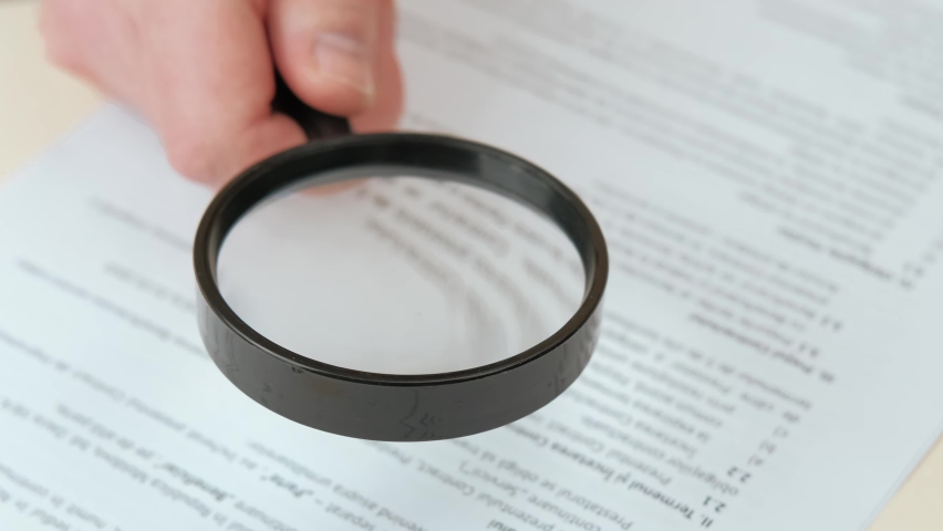 Close up video of reading contract with magnifying glass. | Shutterstock HD Video #1087026104