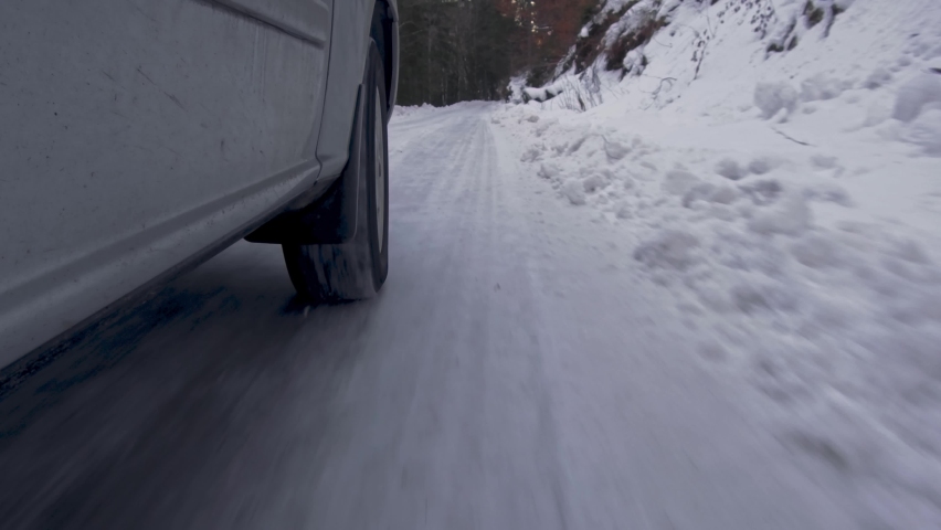 Car Wheel While Driving On Snow Road. Winter mountain road. Royalty-Free Stock Footage #1087031153
