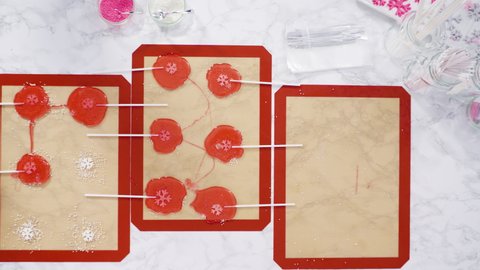 Flat lay. Peeling large homemade lollipops from silicone mat.