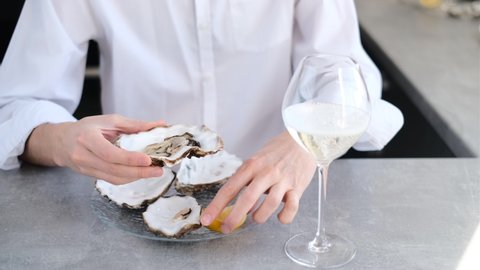 man eating oysters with lemon and wine close-up