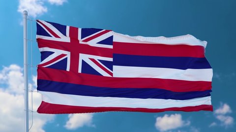 Hawaii flag on a flagpole waving in the wind in the sky. State of Hawaii in The United States of America