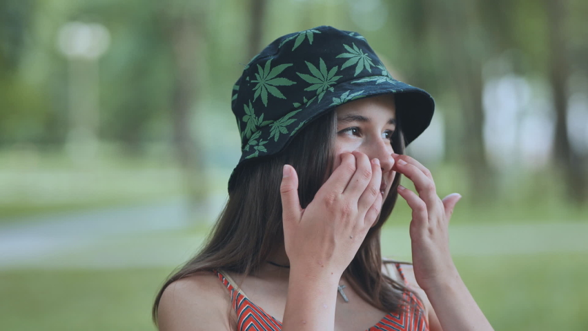 Portrait of a teenage girl in a panama hat in a park in the summer.