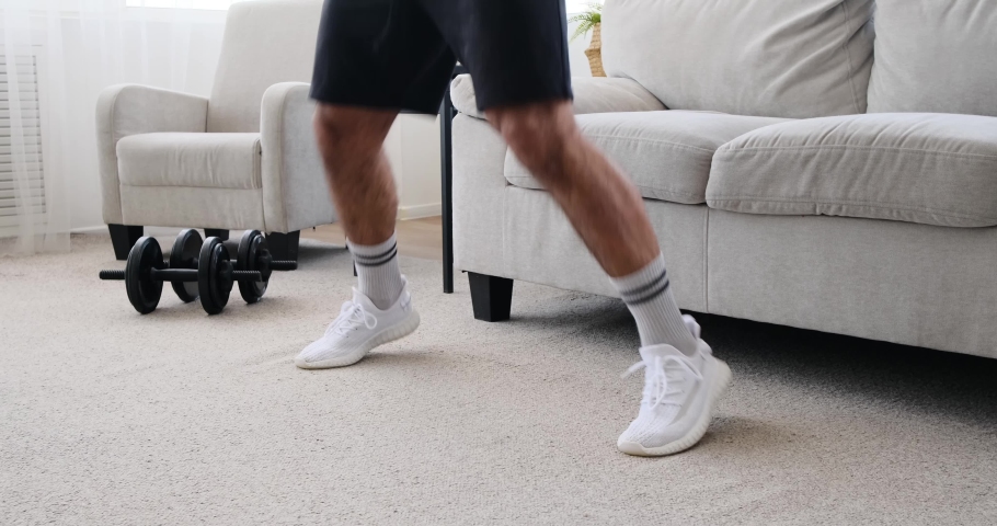 Low section of man doing jumping jack exercise