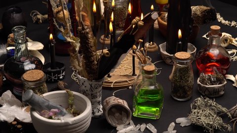 Witch's ceremony with ritual magic items. Magic mushrooms. Still life with black magic candles, dry weeds, animals bones and green potion vial. Halloween concept.