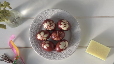 Smearing homemade Easter eggs dyed with onion peels with lard for shine