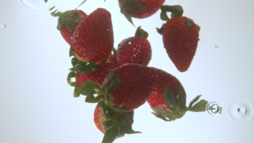 Strawberries falling into water, super slow motion, filmed on high speed cinematic camera at 1000 fps. Royalty-Free Stock Footage #1087057250