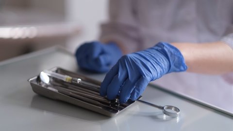 Hands of a female dentist close-up, in a dental office, preparing the anesthetic on the syringe.