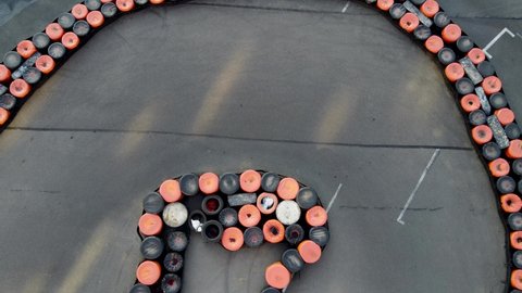Drone top-down view of curvy turn  on a karting track with carts in high speed turns.