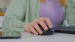Businesswoman clicking mouse. Entrepreneur woman working on modern laptop computer with wireless pointing device in closeup 4k video. Hand of focused freelancer person at work