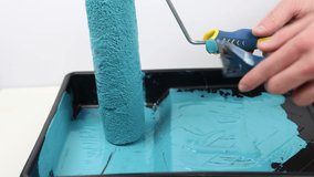 4K video of paint brush or paint roller with blue paint. High quality video showing painting for decorator or builder or artist.