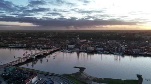 Kampen city aerial view from the river IJssel with the sunset in the distance during a cold winter evening.
