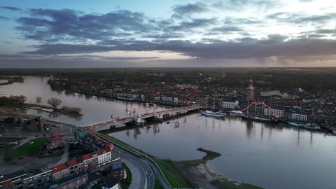 Kampen city aerial view from the river IJssel with the sunset in the distance during a cold winter evening.