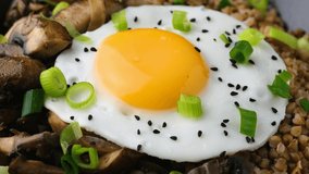 Bowl of Buckwheat with mushrooms, onion and egg. Healthy food. Rotating video