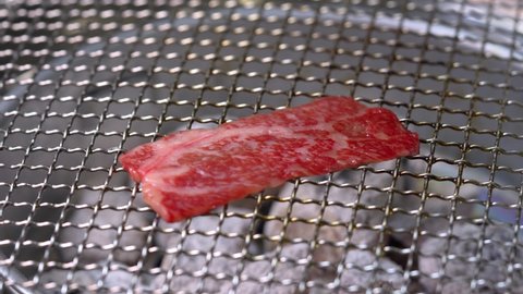 Grilled Wagyu Beef on the charcoal stove, Sliced wagyu red beef on hot charcoal.