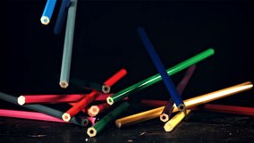 Colored pencils fall on the table. On a black background. Filmed is slow motion 1000 fps. High quality FullHD footage - Powered by Shutterstock - Get 15% off with code: PIKWIZARD15