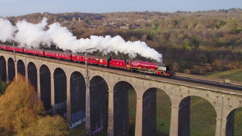 Digswell, Hertfordshire, UK, 12th February, 2022: The "Duchess of Sutherland" steam locomotive pulling carriages crossing the Digswell Viaduct. Aerial tracking panning shot.