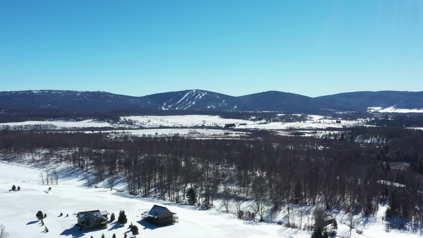 Winter aerial shot of the snow-covered Canaan Valley in  Tucker County, West Virginia. Ski slopes and the Allegheny Mountains are seen in the distance; cabins are seen below in the foreground.