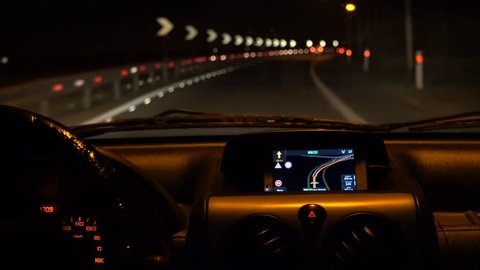 Car driving at night with illuminated dashboard and navigation, POV UHD 4K stock footage