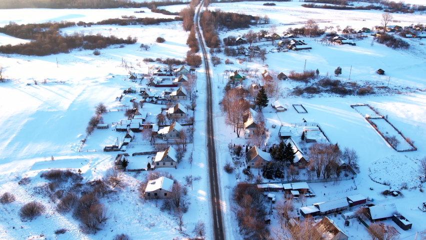 Wooden home in village in winter season. Country houses in countryside in snow. Suburban house at countryside. Aerial view of roofs with snow of with rural homes in winter. Old Russian wooden houses.