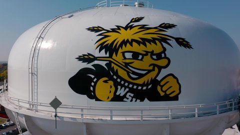 Wichita, Kansas United States of America - November 9 2021: 4K Drone overtake video of water tower on Wichita State University campus in Wichita Kansas with downtown skyline in background