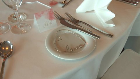 White tablecloth with name card and heart shape in white plate in wedding festive