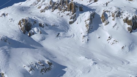 Following a slalom skier riding down dangerous snowy slopes - handheld view