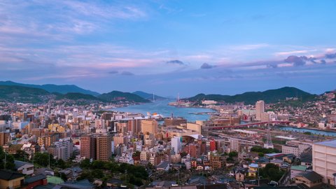 Nagasaki, Japan. Aerial timelapse made from a hill in Nagasaki, Japan, with a view over the entire center, including the bay and the hills. Cloudy and sunny day in summer, zoom in