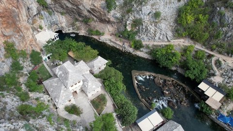 Aerial general drone view of Blagay City historical ottoman lodge built under the rock in Bosnia, dervish lodge built on the side of the Buna river