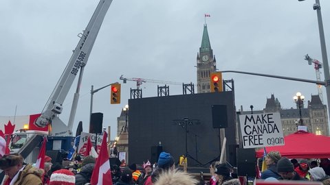 Ottawa Ontario Canada February 11 2022. Freedom Convoy 2022 Canadian Parliament Hill crowd and stage performer protesting against government's COVID-19 vaccine mandate and other restrictions.