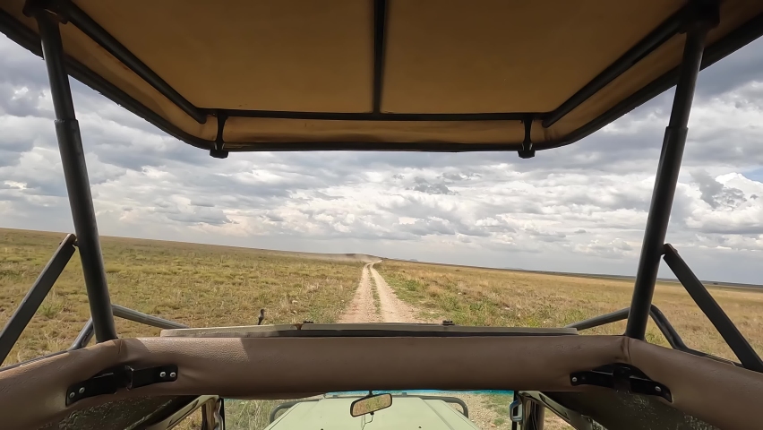 View of the desert fields of Africa from a safari jeep. Panorama of the vast expanses of Tanzania. The beautiful nature of Africa. Special car for safari without windows with an open roof.