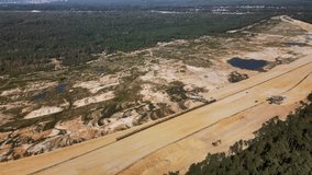 Aerial high altitude orbit over the huge open-pit sand quarry causing environmental problems by lowering the subcutaneous water level