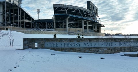 University Park , PA , United States - 01 22 2022: Penn State University, PSU and Beaver Stadium. Establishing shot of logo and sign in winter snow.