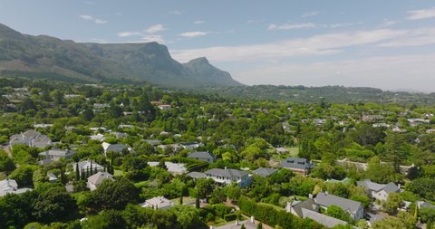 Residential borough on city outskirts. Modern family houses surrounded by green vegetation. Mountain in background. Cape Town, South Africa